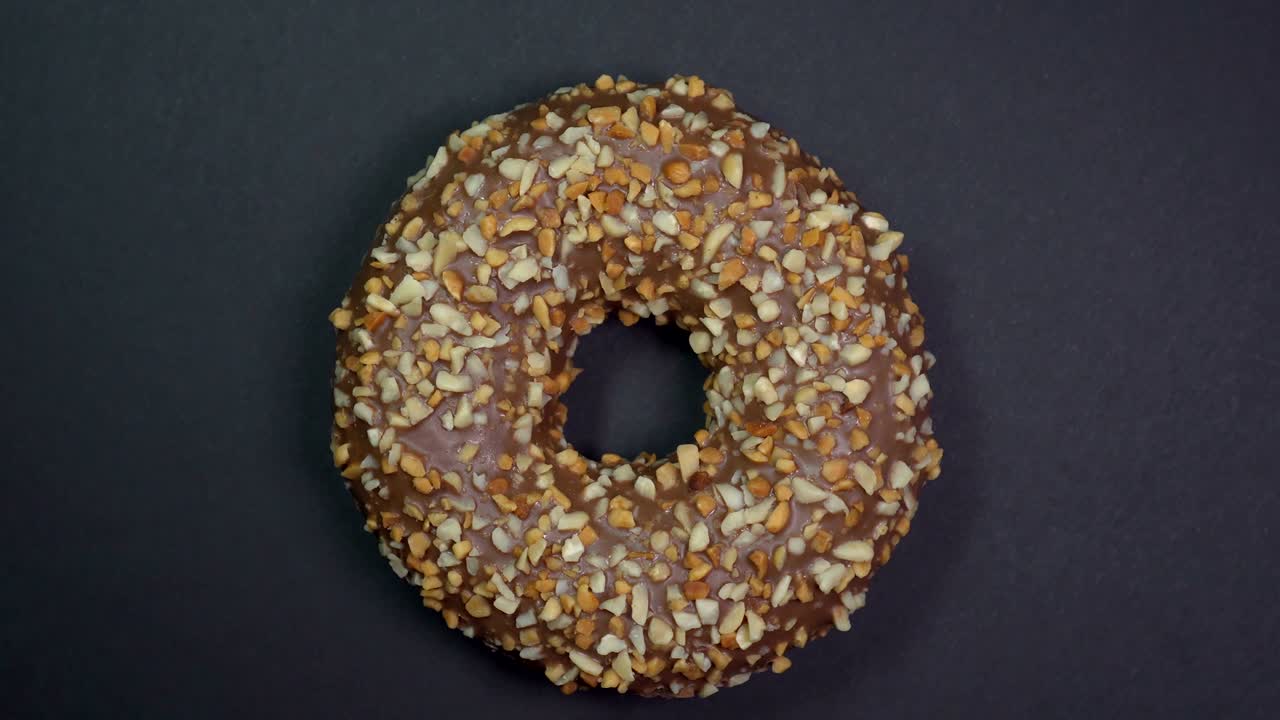 saboroso y fresco rosquilla rosquilla macro disparo de primer plano girando sobre un fondo negro.