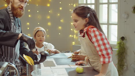 chef giving knives to kids for cutting pears on cooking class