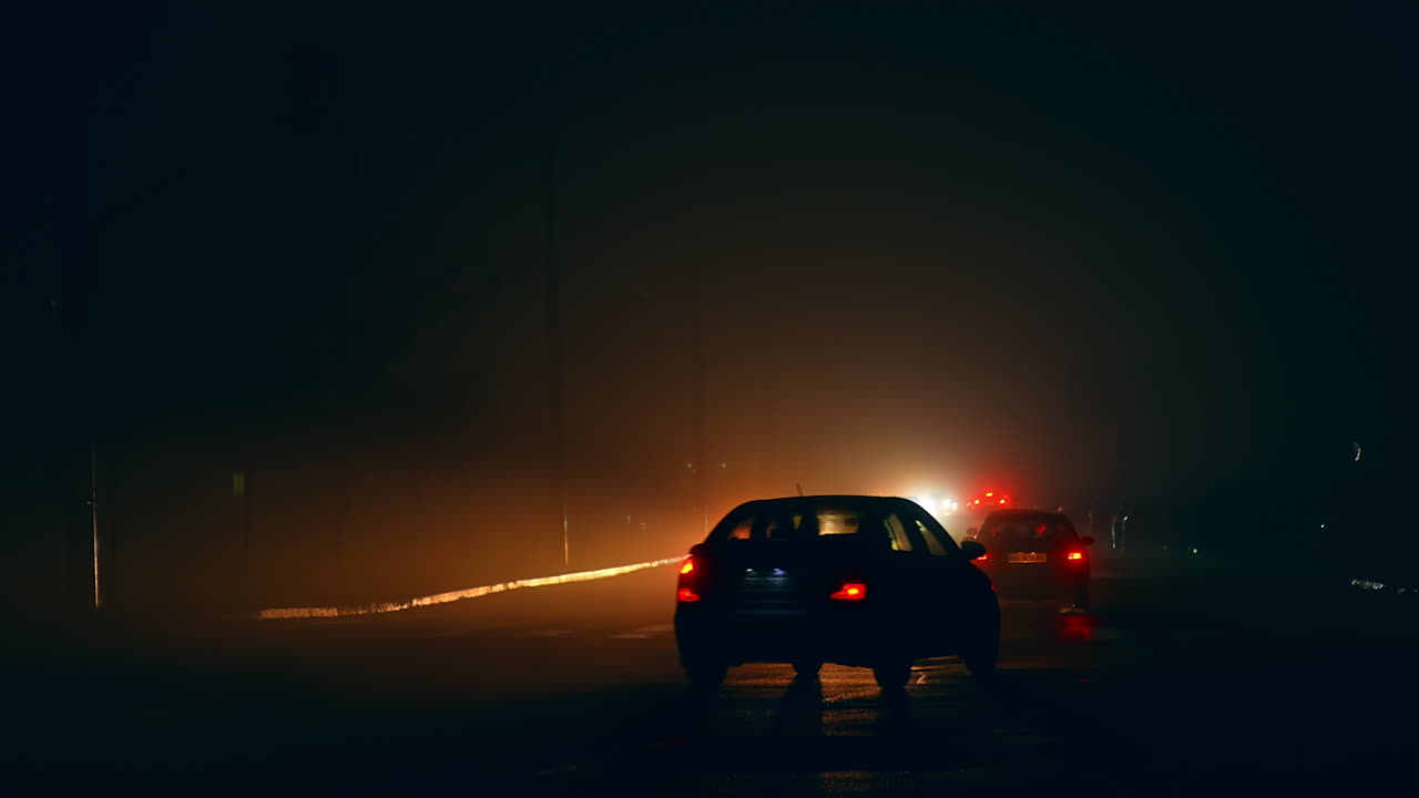 Cars driving on a foggy night road