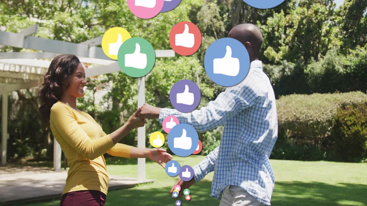Coppia che si saluta con le mani unite sotto un pergolato, generando icone di reazione dei social media.