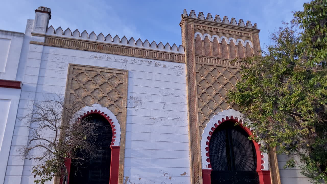 Vista esterna di una facciata di edificio a Sanlúcar de Barrameda, Spagna, che mostra caratteristici dettagli architettonici mudejar e andalusi.