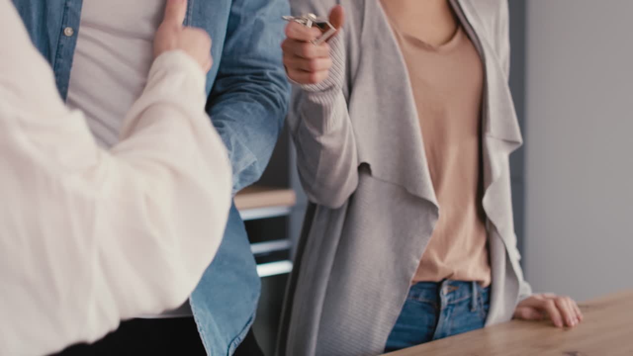 젊은 백인 부부가 부동산 중개인과 집 구매 계약을 체결하고 있습니다.