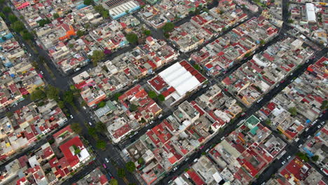 Aerial-fly-over-Salvador-Diaz-neighborhood-house-buildings-with-cars-driving-in-road-traffic