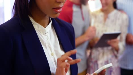 Businesswoman-Using-Mobile-Teléfono-In-Office