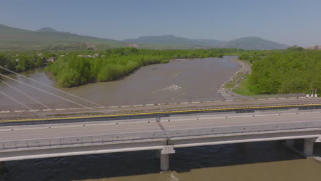 slow descending shot of a large bridge with a river running below