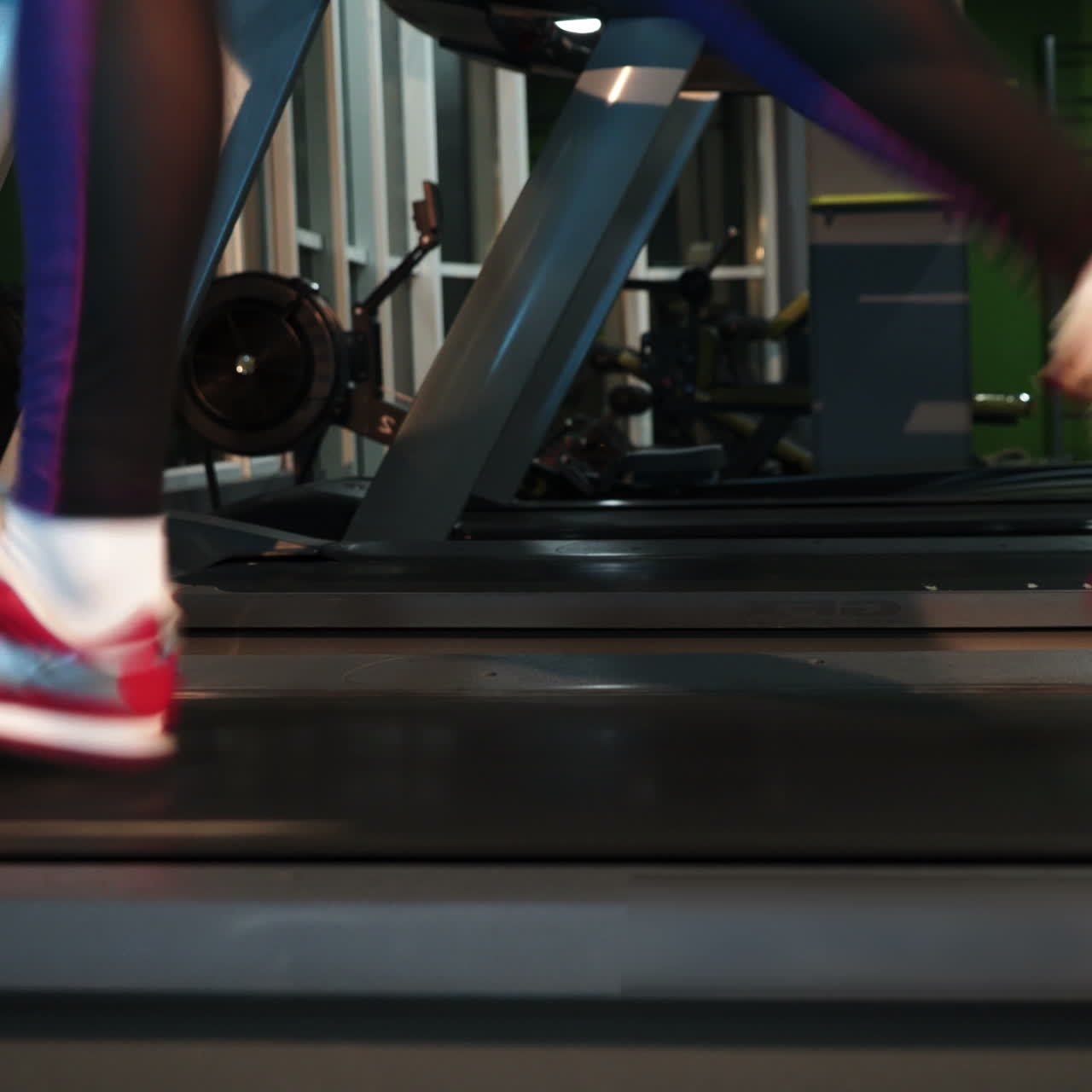 Female muscular feet in sneakers running on the treadmill at the gym. Concept for fitness, exercising and healthy lifestyle. Square video