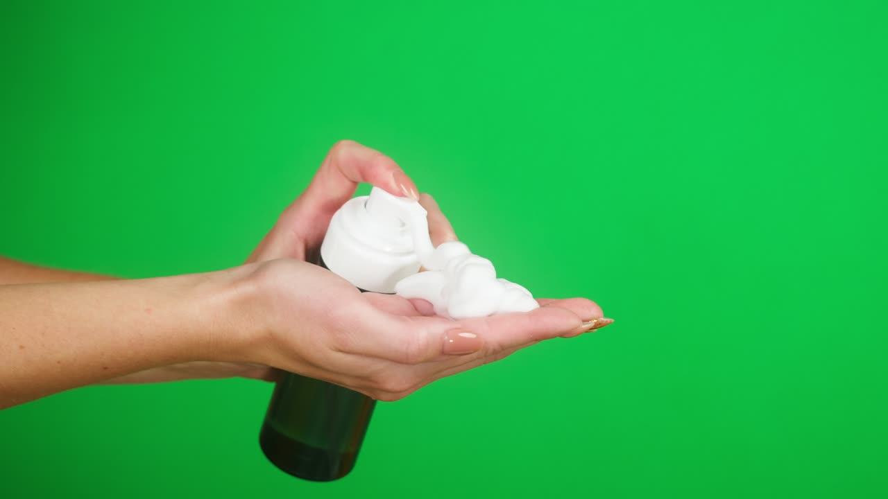 녹색 바탕에 액체 비누 또는 거품을 사용하여 여성 손을 는 바이러스 예방, 안전 보호, 항균 거품 소독제를 가까이 들고 있는 팔