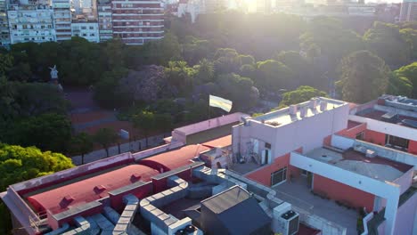 Aerial-view-dolly-in-of-the-Argentine-flag-with-an-epic-sunset-in-the-background-and-the-sunlight-illuminating-the-light-blue-and-white-colors