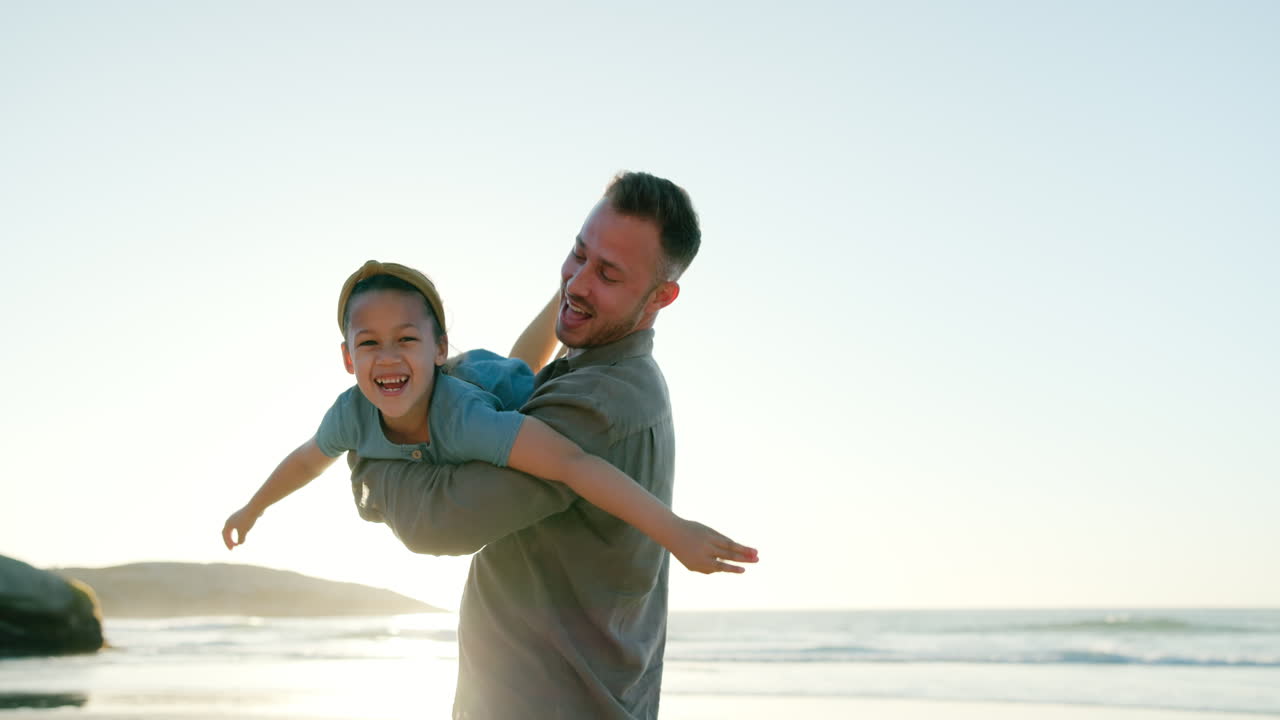 夕暮れのビーチで遊んでいる父と娘