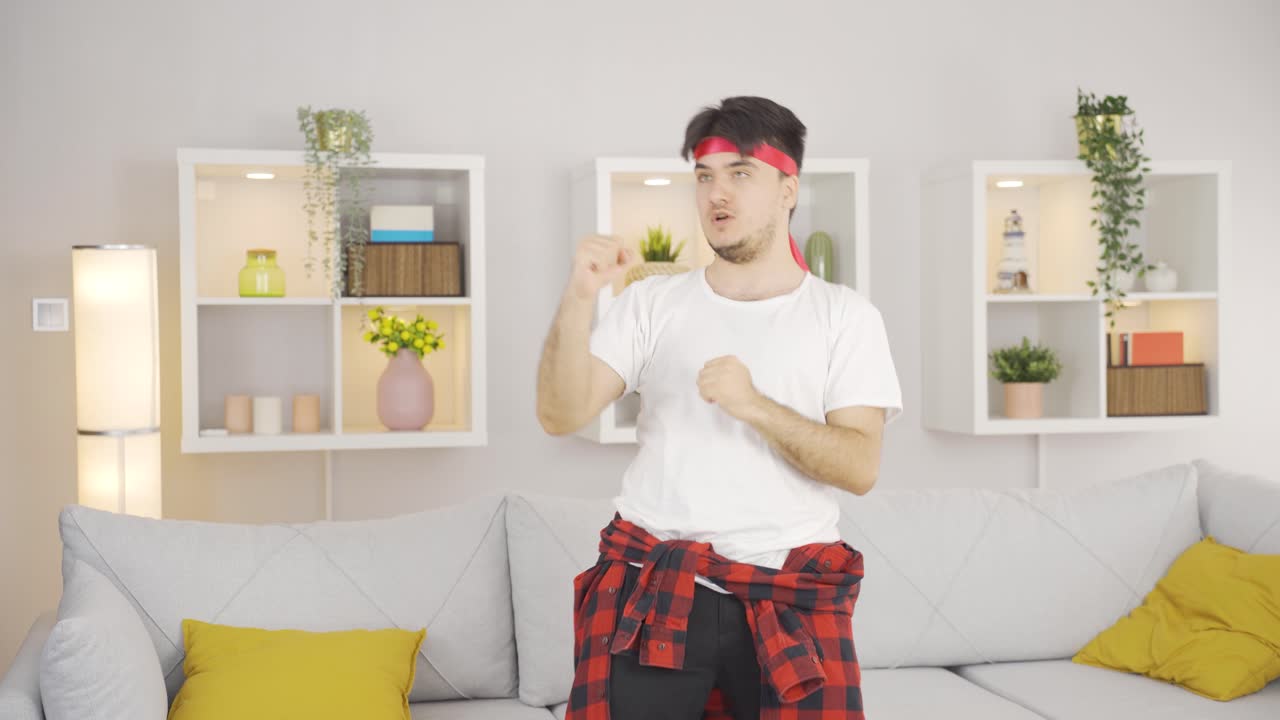 집에서 웃긴 방식으로 권투하는 남자.