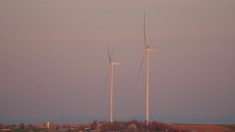 wind turbines against a pink and purple sky