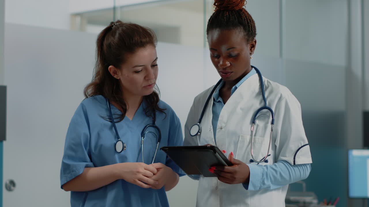 Due professioniste mediche che discutono le informazioni sui pazienti su un tablet