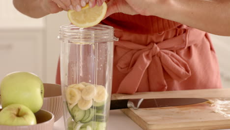 preparing fresh smoothie with bananas and cucumbers in modern kitchen