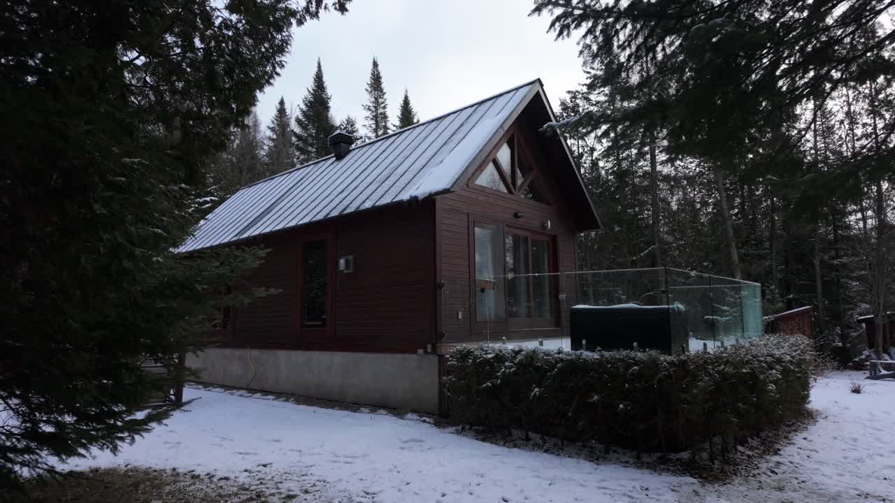 클레르무스티에 호수 근처의 눈으로 인 나무들 사이에 자리잡은 쾌적한 오두막은 캐나다 페티-체르시에서 따뜻하고 평온한 분위기를 발산합니다.