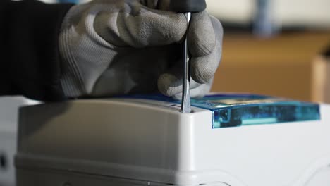 hand of an engineer working on w machine with his screwdriver