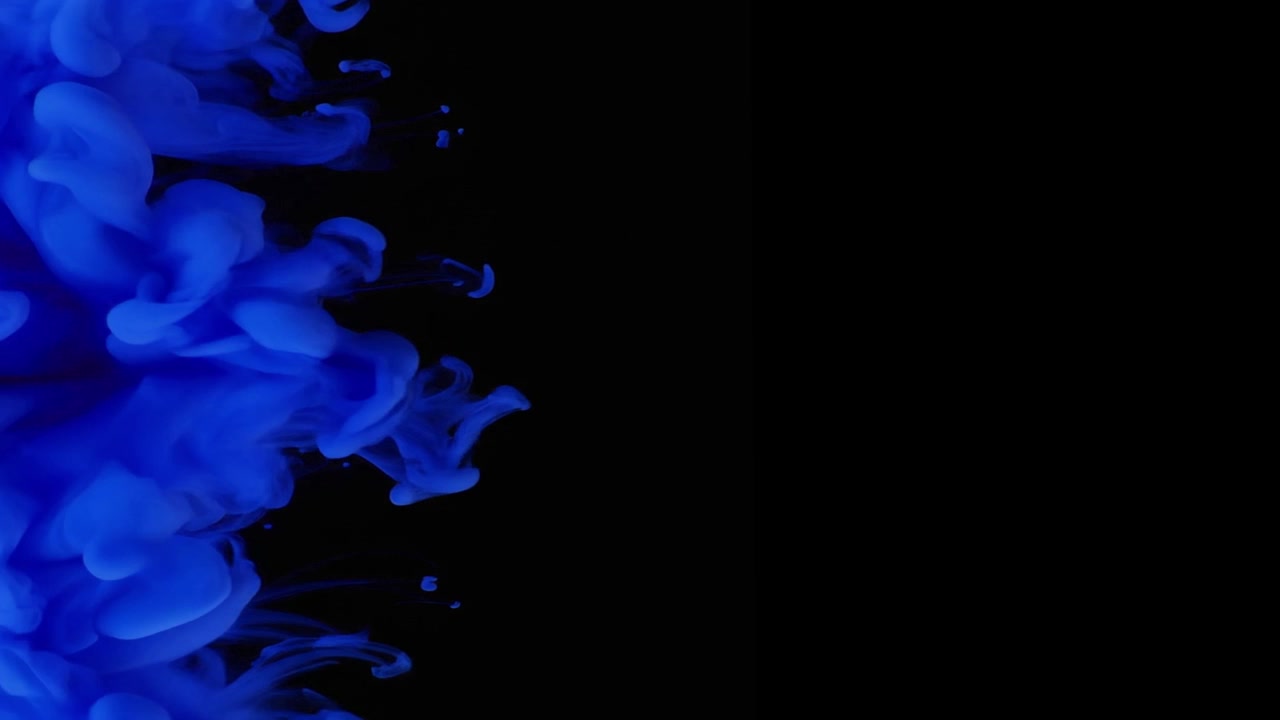 Inchiostro blu che turbina nell'acqua su sfondo nero