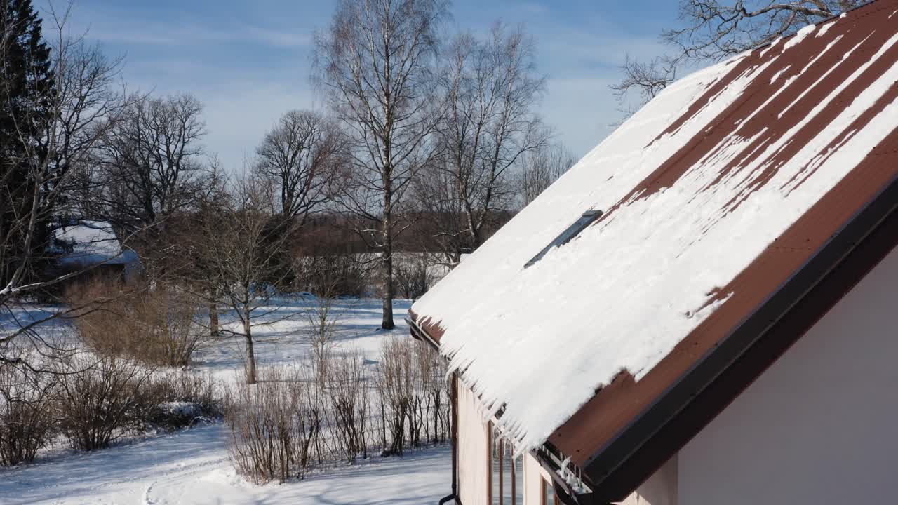 Snow accumulated on a roof. Snow on a family home in countryside. Aerial winter view.