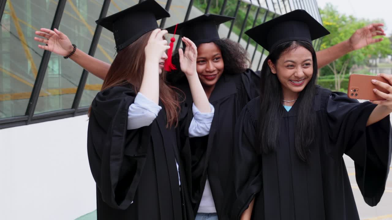 student wearing gown and making photo by smartphone  graduating. Happy graduate success and celebration. Congratulation