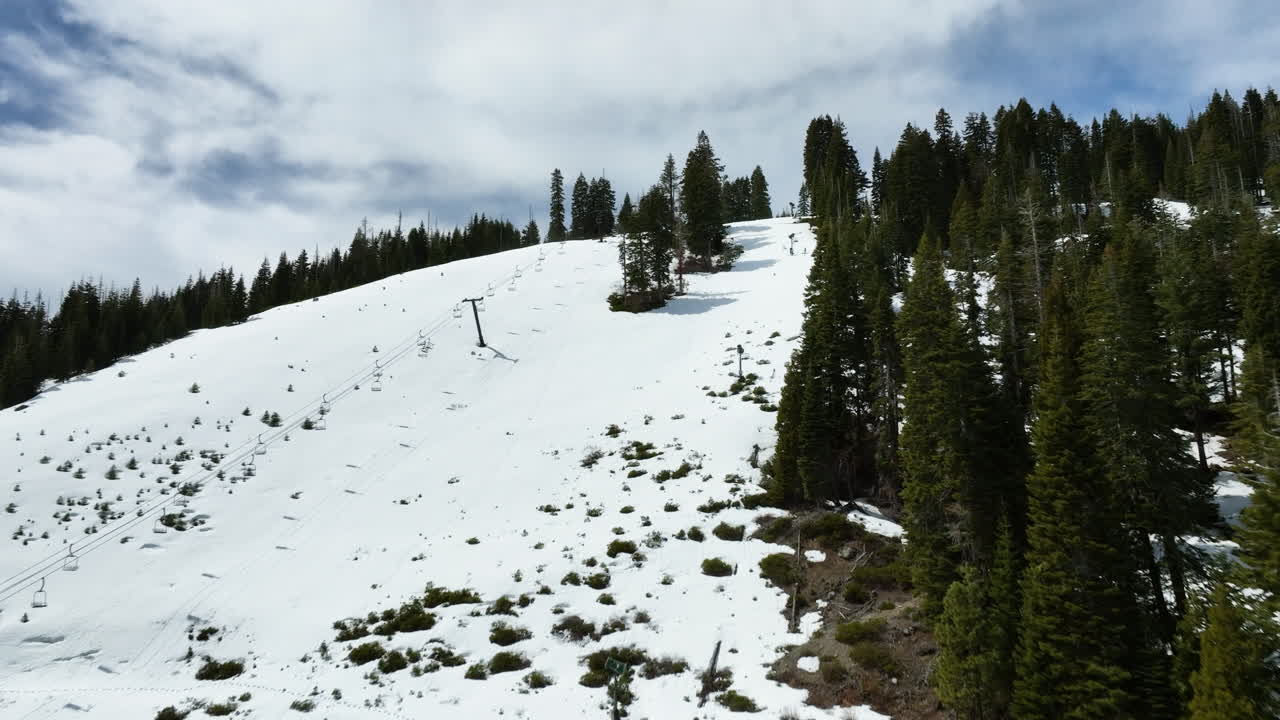 Aerial view rising over snowy ski slopes of Tahoe, sunny, winter day in USA