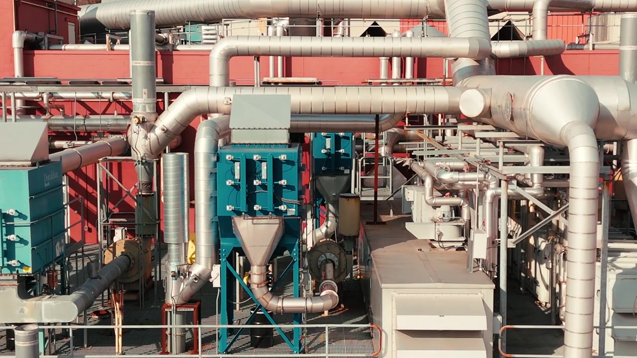Primo piano di un sistema HVAC sul tetto con tubi e condotti, focus sul design industriale ad alta efficienza energetica, carrellata a destra