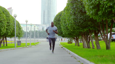 Young-Man-Listening-To-Music-With-Headphones-While-Running-In-The-Park