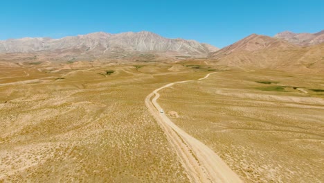 Vuelo-Sobre-Un-Sendero-Interminable-Con-Vehículo-De-Conducción-Hacia-Los-Lagos-Arashan,-Namangan,-Valle-De-Ferghana,-Uzbekistán,-Asia-Central