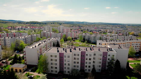 aerial view of a residential district in a polish town on a sunny day. rows of apartment blocks surrounded by greenery, showing a peaceful urban neighborhood from above
