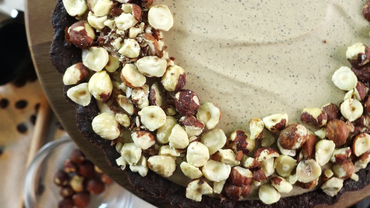 A delicious dessert, Coffee Hazelnut Cream Tart. Made with espresso powder, chocolate crust and loaded with crushed hazelnut. Cloe up of the pie or tart going around in a circle. Bakery desserts