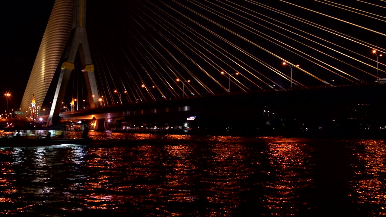 un barco navega bajo el puente de cable