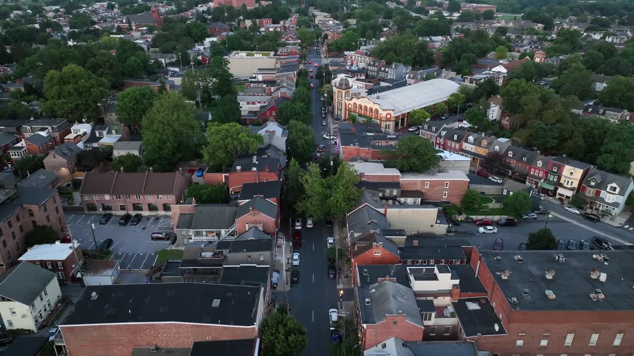 Cars on main street of American city at dusk. Colored townhouses and row homes in Lancaster, Pennsylvania. Cloudy summer day in small city of Pennsylvania. Aerial Birds Eye shot