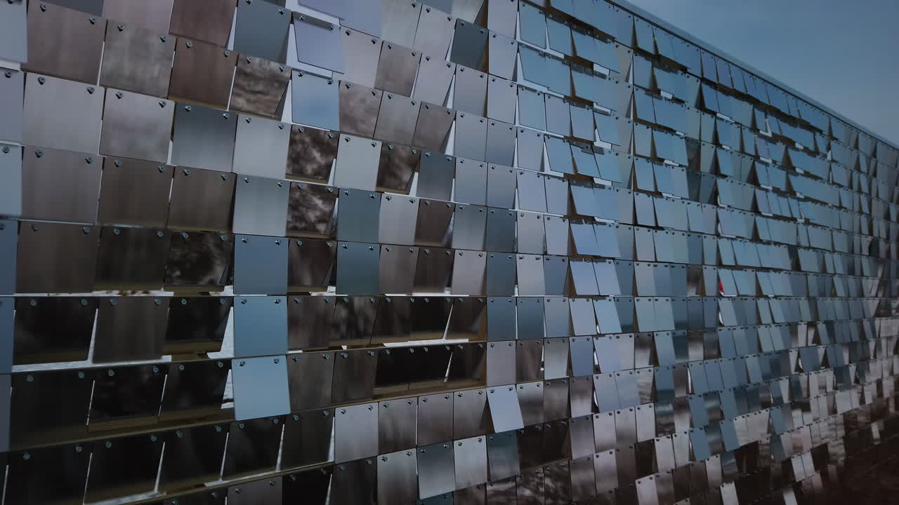 A wall of reflective rows of plexiglass panels moving in tandem with a fast wind, wide shot