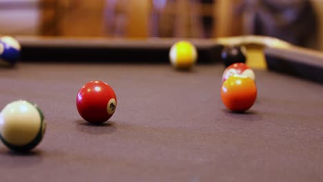 playing a game of pool with balls rolling over billiard table