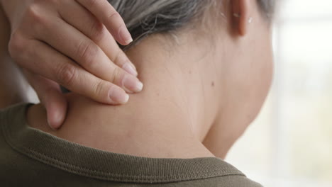 back view of a middle aged woman having neck pain