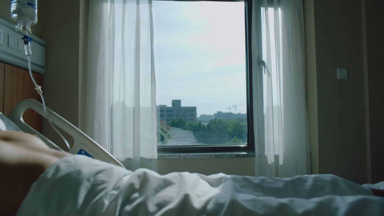 Un paziente uomo adulto con flebo respira e riposa su un letto d'ospedale di fronte alla finestra, con la brezza che muove le tende.