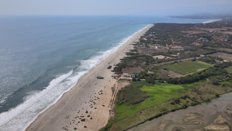 Aerial-view-of-beach-in-puerto-escondido,-Oaxaca,-with-waves-and-sand