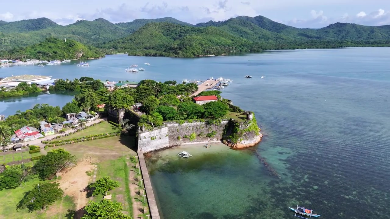 Ripresa aerea a spirale discendente con drone attorno al Forte Santa Isabel a Taytay, Palawan, mostrando dall'alto la fortezza coloniale spagnola in pietra corallina.