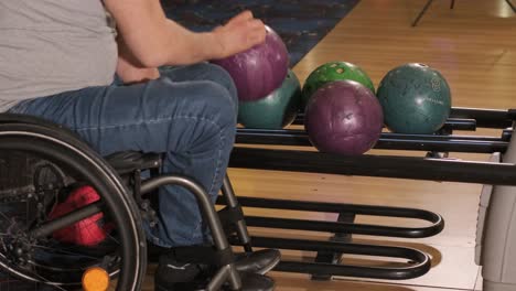 two young disabled men in wheelchairs playing bowling in the club