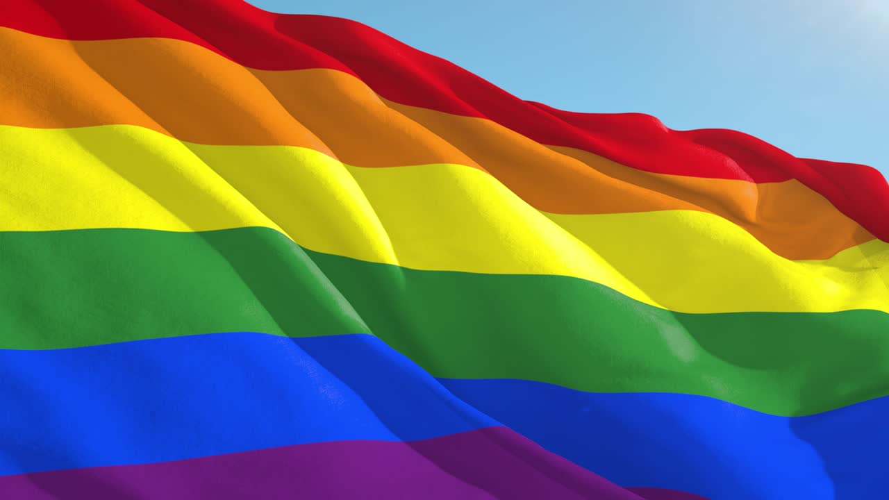 hermosa cámara lenta agitando la bandera del arco iris del orgullo gay y los derechos.