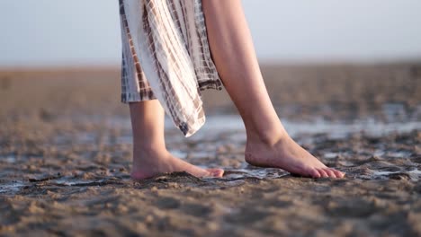 ángulo-Bajo-Y-Primer-Plano-De-Los-Pies-De-Una-Niña-Sobre-Una-Arena-Mojada-En-Una-Playa-Cerca-Del-Mar