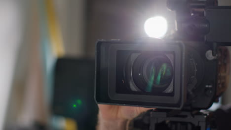 primer plano del operador de cámara de cine masculino enfocando la lente en la cámara grabando una película o video en el estudio 1