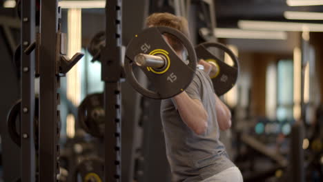 Young-fitness-man-doing-barbell-squats-at-gym.-Sportsman-training-in-sport-club