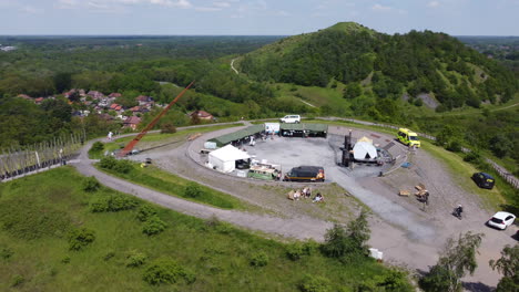 Festival-Preparation-on-Top-of-Mine-Slag-Heap,-Beringen-AERIAL-ORBIT