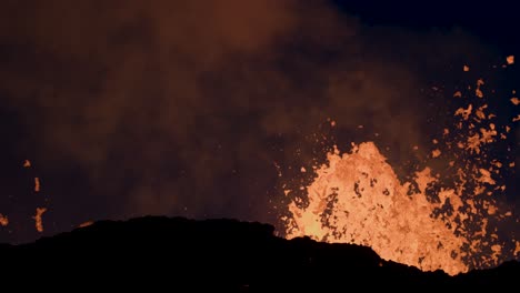 hot molten magma spewing from crater mount in iceland at night