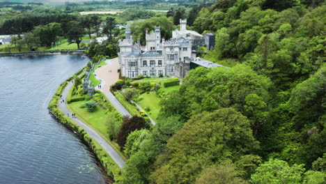 descending aerial view of kylemore abbey and the lough