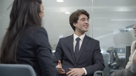 cheerful coworkers shaking hands and talking