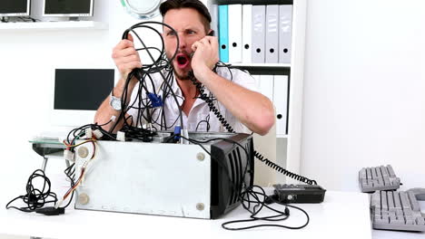 Angry-technician-pulling-wires-in-broken-computer