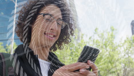 Young-biracial-man-texts-on-his-phone-outdoors,-with-copy-space