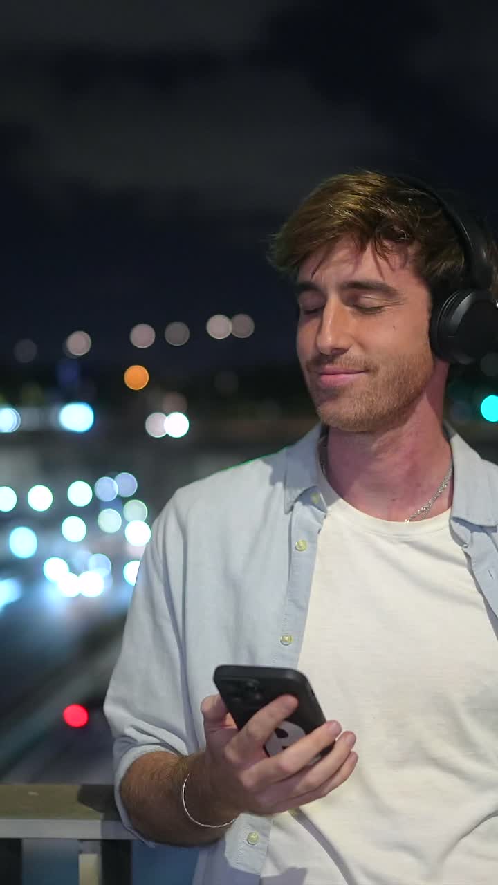 Man with Headphones and Phone at Night