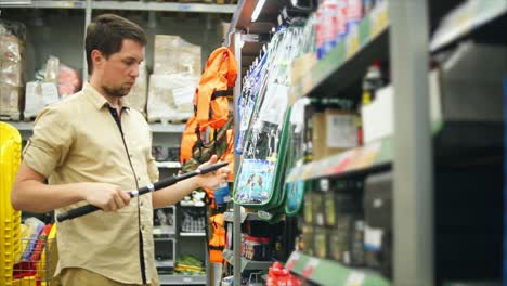 hombre comprando equipos de pesca en una tienda de artículos deportivos