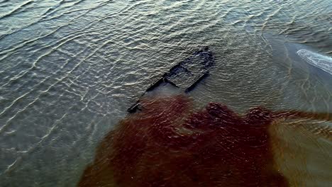 aerial-view-of-a-old-shipwreck-in-blue-ocean-with-a-dark-gray-old-wreck-along-the-surface